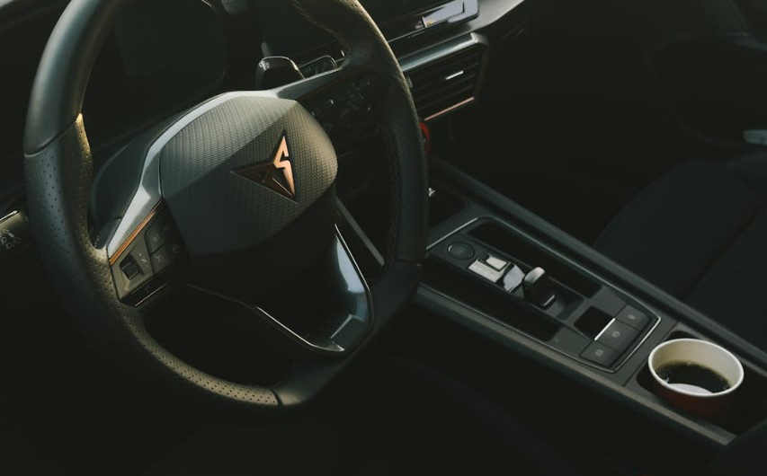 Sleek modern car interior featuring a stylish steering wheel and console.
